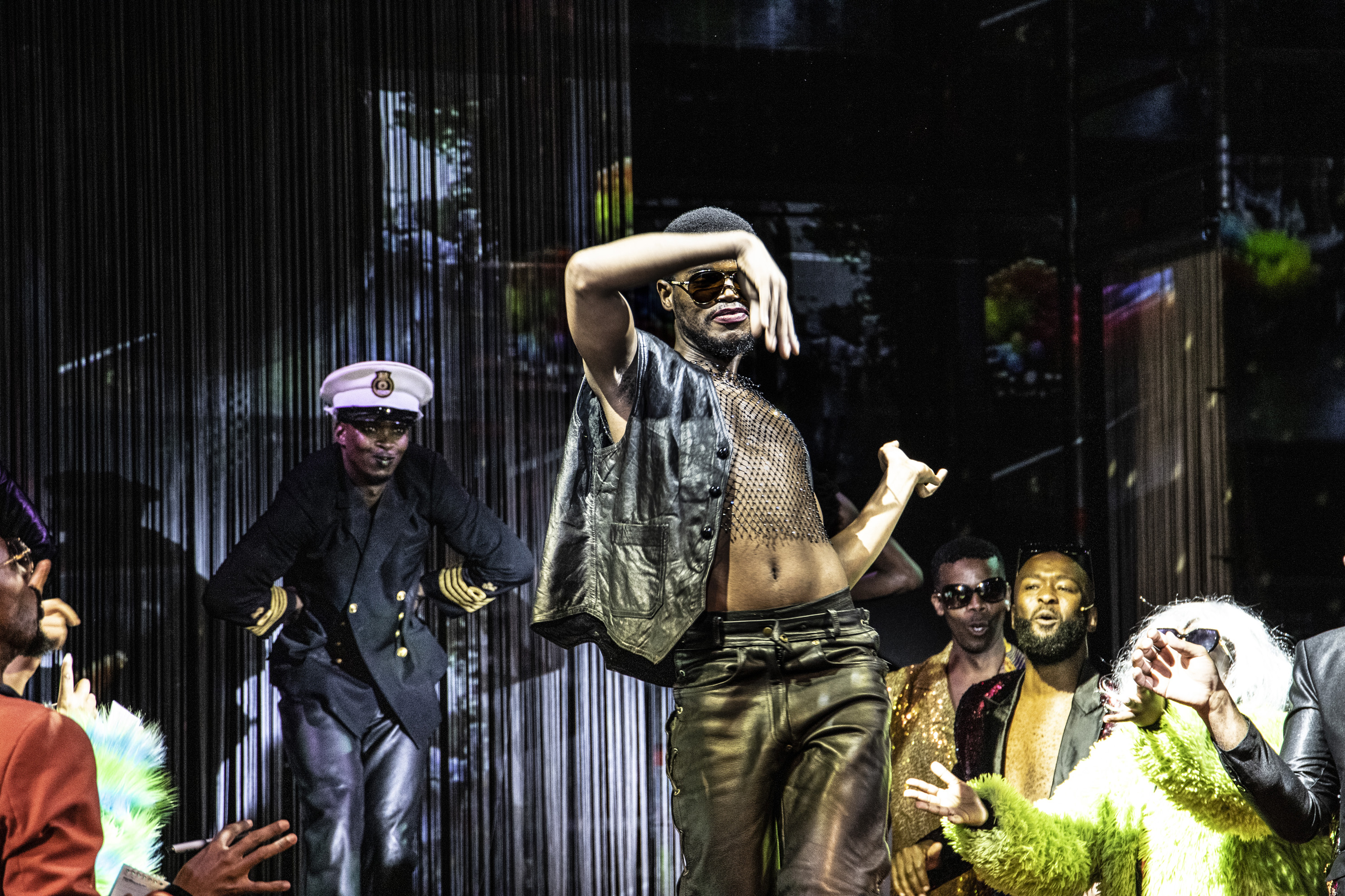 Simon Nkoli played by Simbone Qonya sings in Philip Miller’s Nkoli: the Vogue-Opera, along with his chorus of fans, press and activists, “Super Gay”. © Mark Lewis